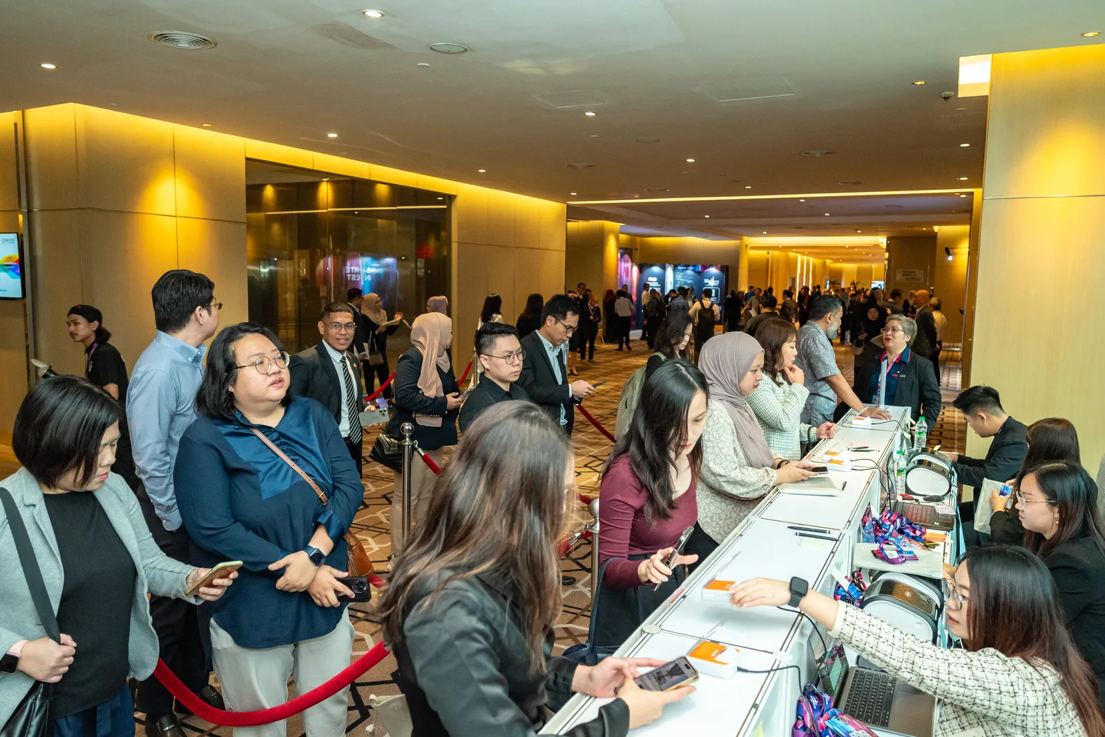 Crowd of attendees checking in at a corporate event registration area