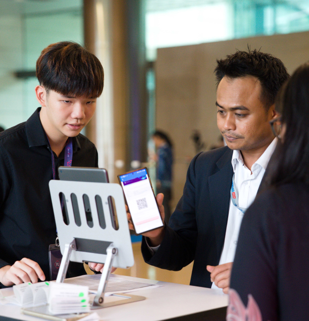Event attendees checking in using QR code ticketing at the registration counter.